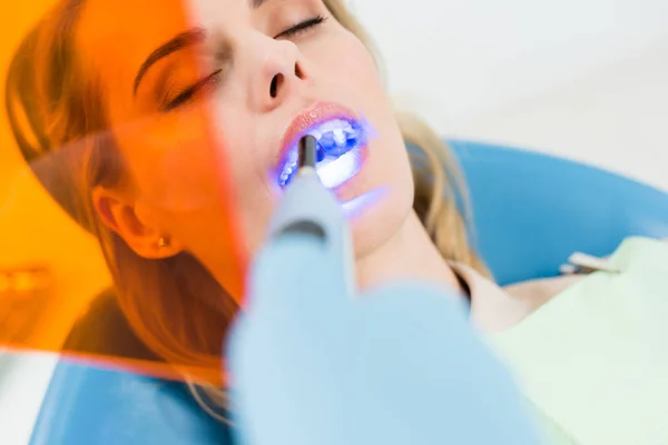 Paciente Feminina Procedimento Odontológico Usando Lâmpada Clínica Odontológica Moderna — Fotografia de Stock