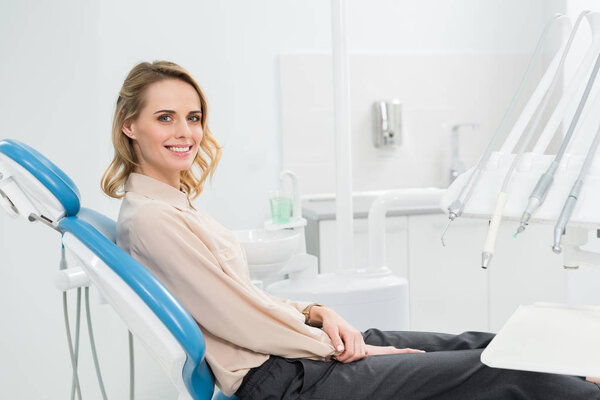 Улыбающаяся женщина на осмотре в современной стоматологической клинике
