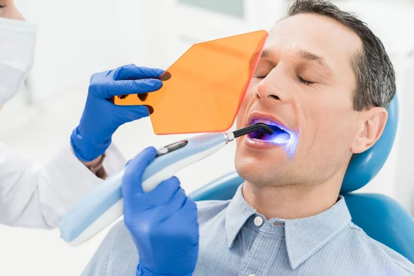 Patient Masculin Procédure Dentaire Utilisant Lampe Dans Clinique Dentaire Moderne — Photo