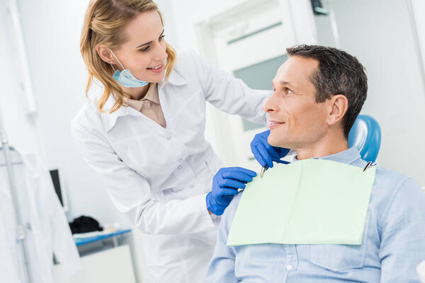 Врач чинит мужскую салфетку в современной стоматологической клинике
