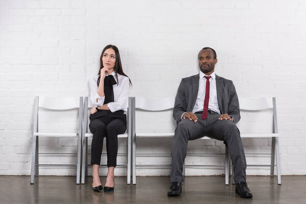 asian businesswoman and african american businessman waiting for job interview 