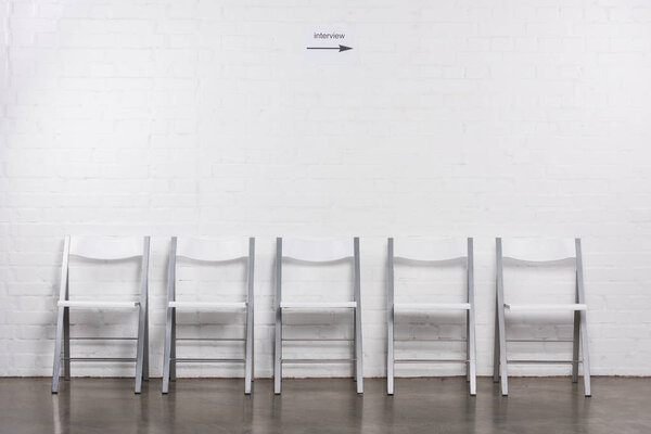 close up view of arranged empty chairs in hall for visitors of job interview