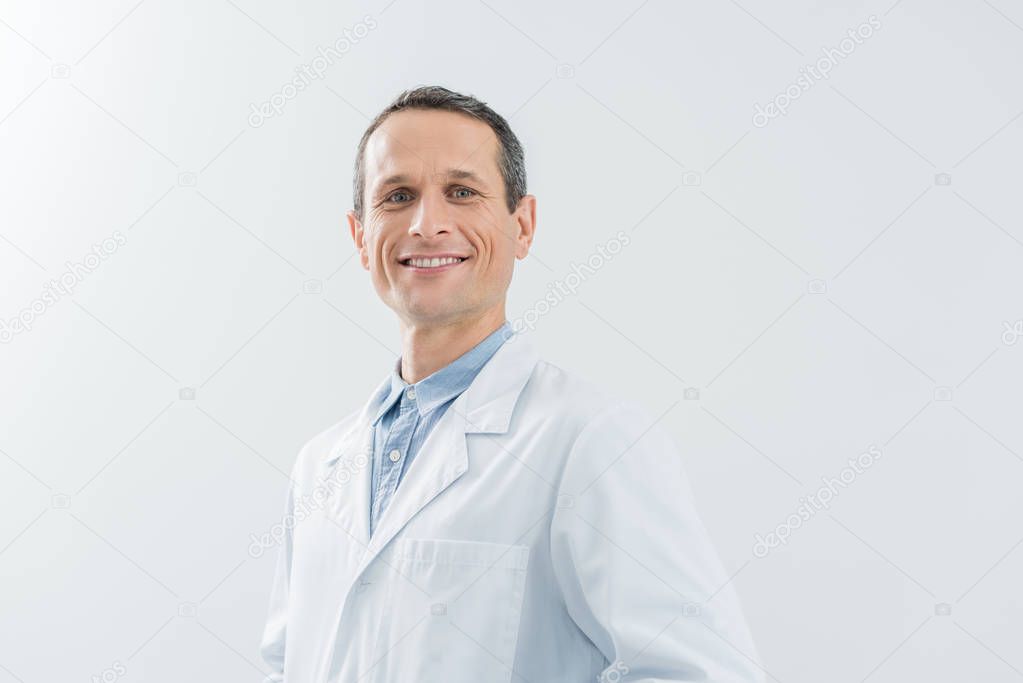 Smiling confident doctor by the wall in modern clinic