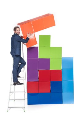 businessman on ladder collecting colorful blocks isolated on white clipart