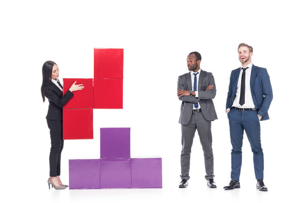 asian businesswoman collecting colorful blocks with multiethnic businessmen near by isolated on white, business cooperation concept