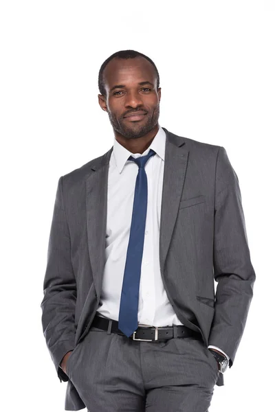 白で隔離のポケットに手でスーツで笑顔のアフリカ系アメリカ人実業家 — ストック写真