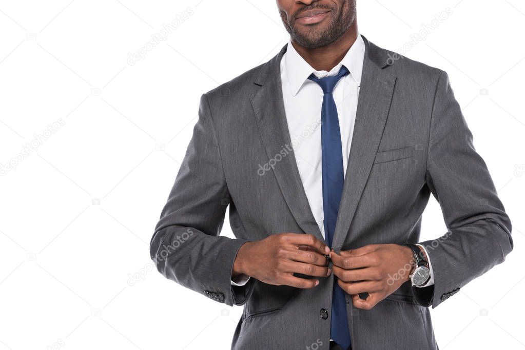 cropped shot of african american businessman buttoning suit isolated on white