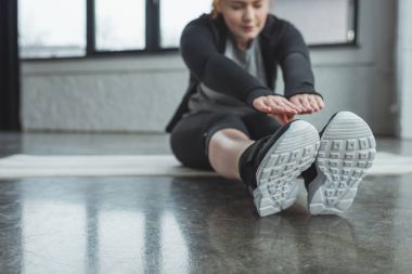 Kilolu kız parmaklarını spor salonunda ulaşan