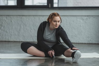 Obez kız spor salonunda katta germe