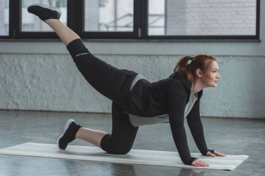 Kilolu kız spor salonunda egzersiz gerçekleştirme