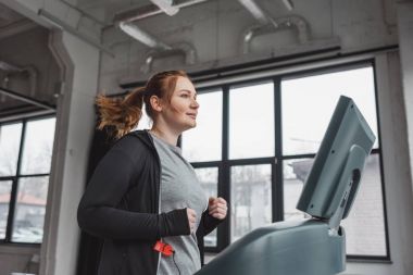 Obez kız spor salonunda treadmill eğitim