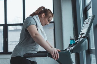 Obez kız spor salonunda treadmill dinlenme