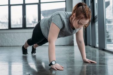 Spor salonunda push up gerçekleştirme kız kilolu