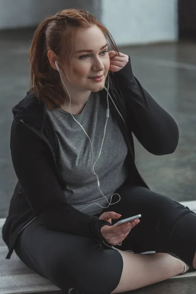 Υπέρβαρη Κοπέλα Ακούτε Μουσική Στο Smartphone Στο Γυμναστήριο — Φωτογραφία Αρχείου
