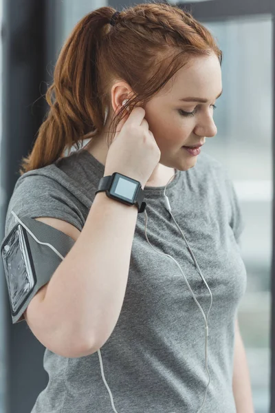 Kurvig Tjej Med Fitness Tracker Lyssna Musik Gymmet — Stockfoto