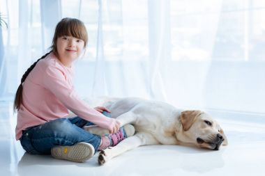 Down sendromu ile Labrador köpek pençe tutan çocuk 