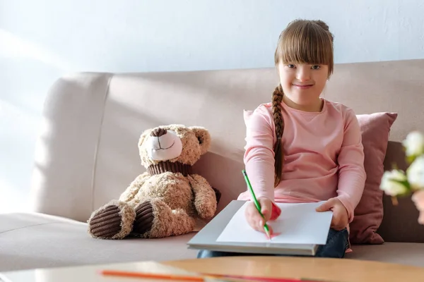Улыбающийся Ребенок Синдромом Дауна Рисует Красочными Карандашами — стоковое фото