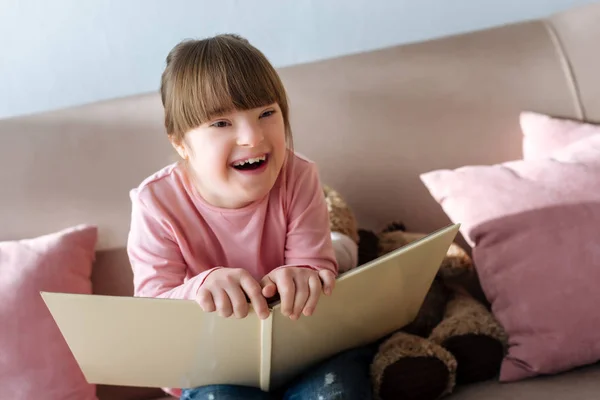 Kind Mit Syndrom Hält Buch Und Lacht — Stockfoto