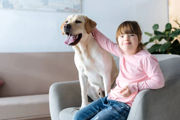 Dziecko Downa Głaskanie Labrador Retriever Pies Siedzi Fotelu — Zdjęcie stockowe