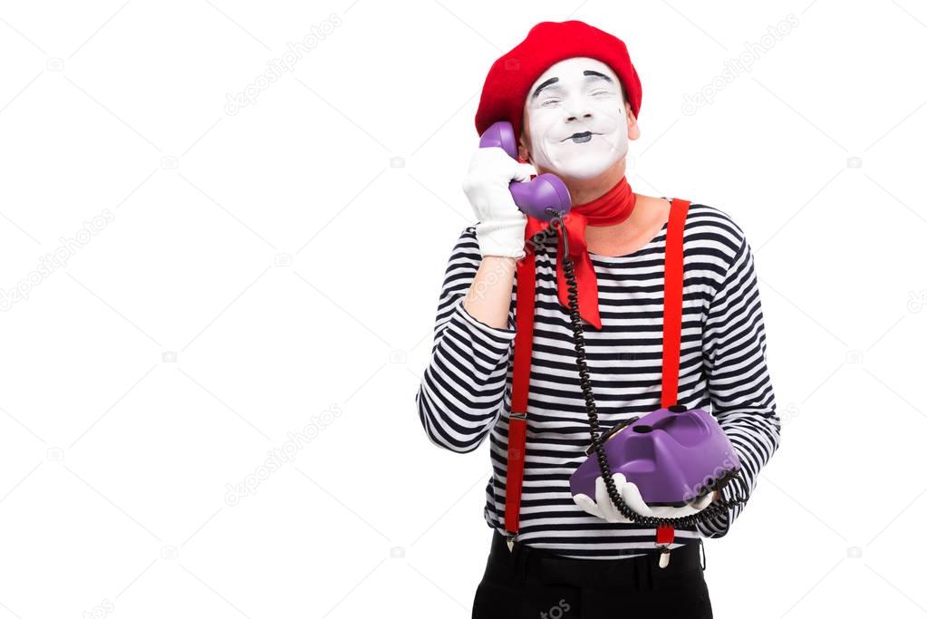 happy mime talking by retro stationary telephone with closed eyes isolated on white