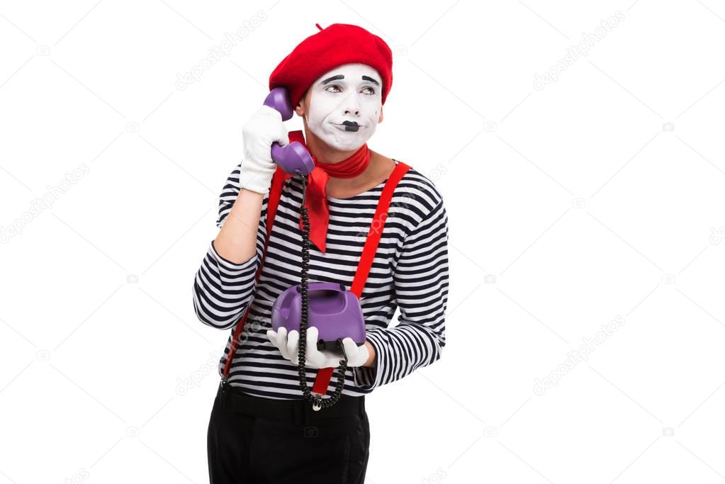 skeptical mime talking by ultra violet retro stationary telephone isolated on white