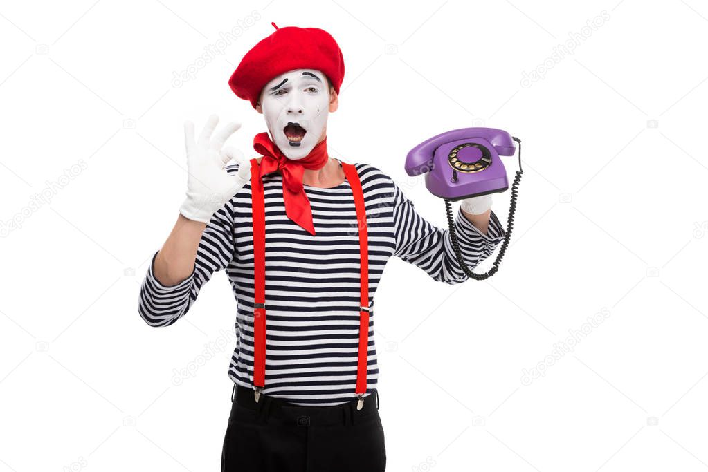 mime holding ultra violet retro stationary telephone and showing ok sign isolated on white