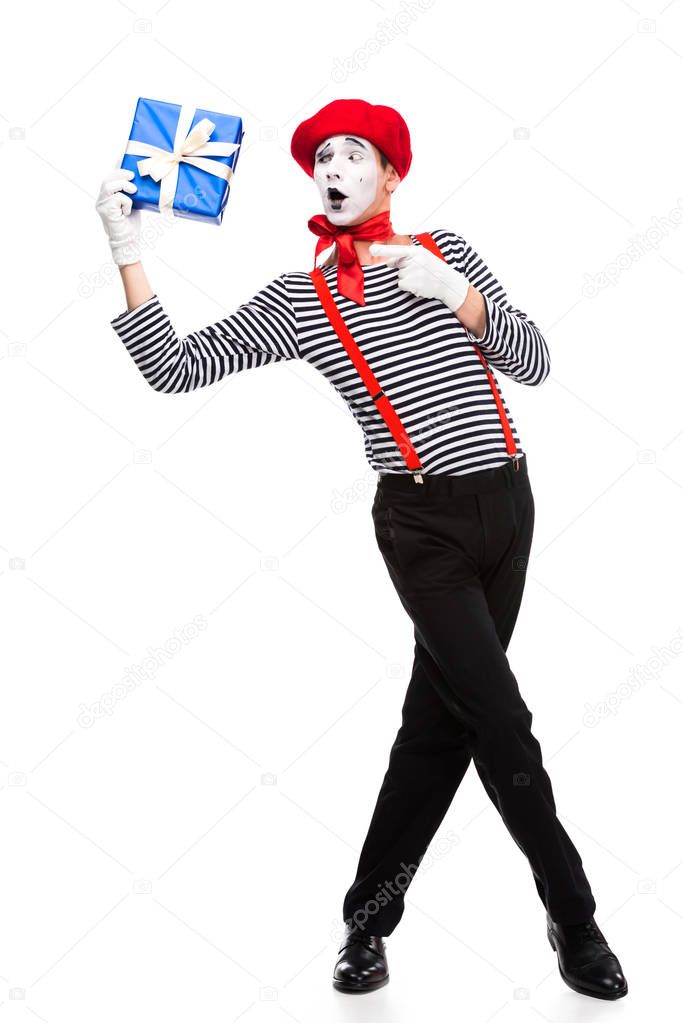 surprised mime pointing on gift box isolated on white
