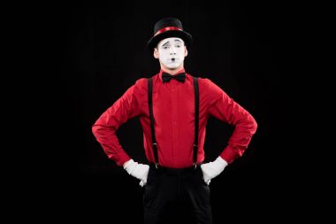 grimacing mime standing with hands akimbo isolated on black clipart