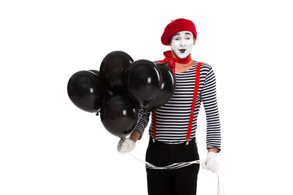 cheerful mime holding bundle of balloons with helium isolated on white