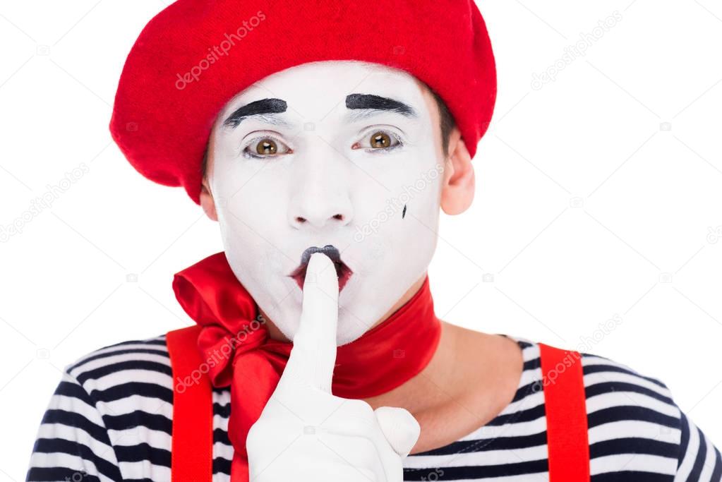portrait of mime showing silence gesture isolated on white