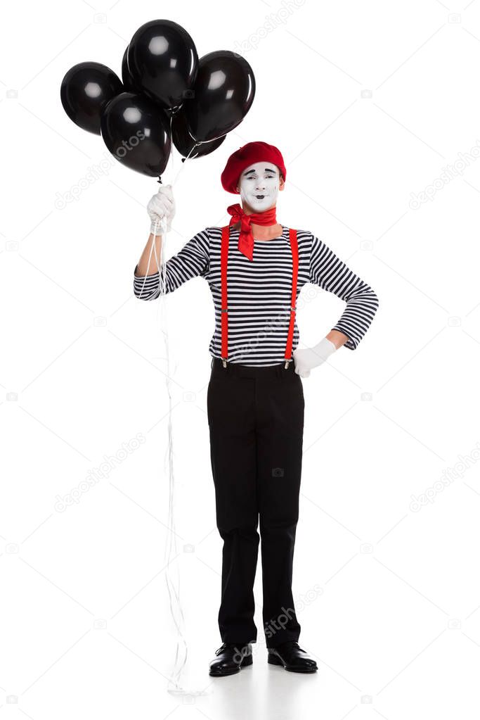cheerful mime holding bundle of black balloons with helium isolated on white