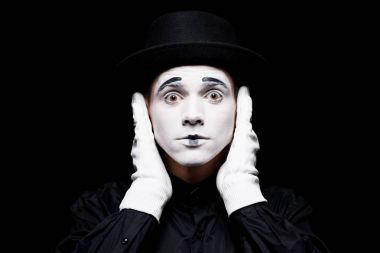 mime covering ears and looking at camera isolated on black clipart