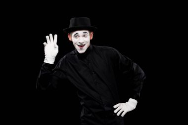 happy mime waving hand isolated on black