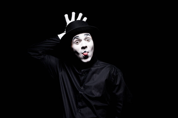 mime sticking tongue out and grimacing isolated on black