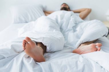 seçici odak bir yatak, ön plan ayakta uyuyan adam 