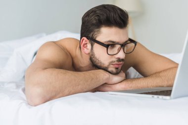 dizüstü yatakta bakarak gözlük yakışıklı sakallı adam