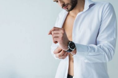 handsome man in white shirt wearing wristwatch, isolated on grey