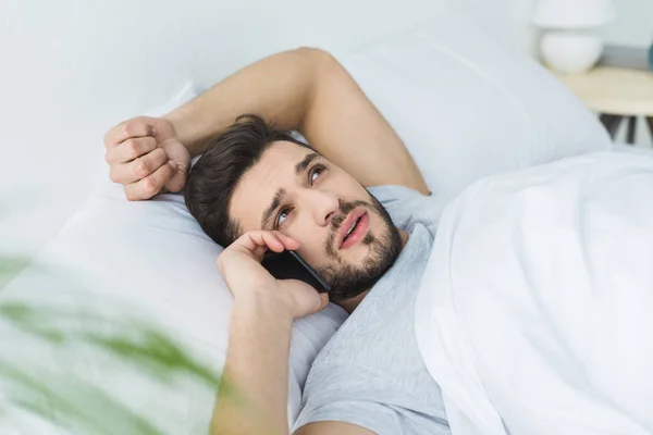 Skäggig Man Liggande Sängen Och Talar Smartphone Morgonen — Gratis stockfoto