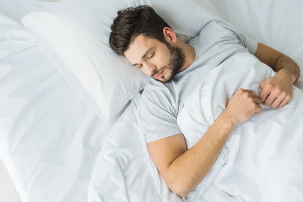 ベッドで寝ている髭の男のトップ ビュー — ストック写真