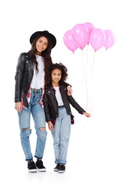 Anne ve kızı benzer giysileri üzerinde beyaz izole pembe balonlu gülümseyen