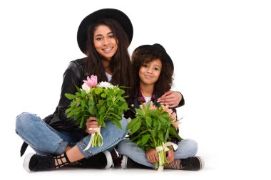 mother and daughter sitting on floor with beautiful bouquets isolated on white clipart