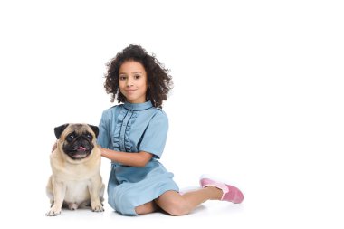 mutlu küçük çocuk üzerinde beyaz izole pug ile katta oturan elbiseli