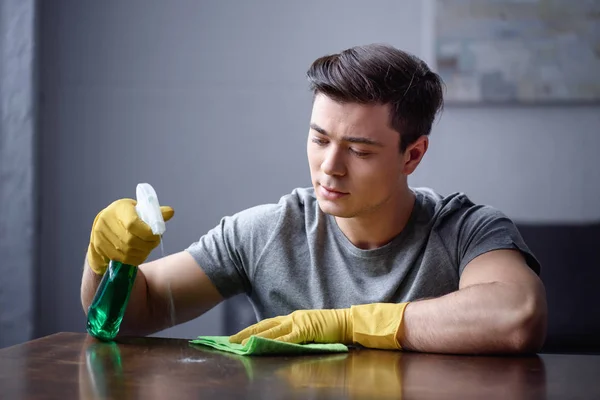 Mann Putzt Tisch Wohnzimmer Mit Sprühflasche Und Lappen — Stockfoto