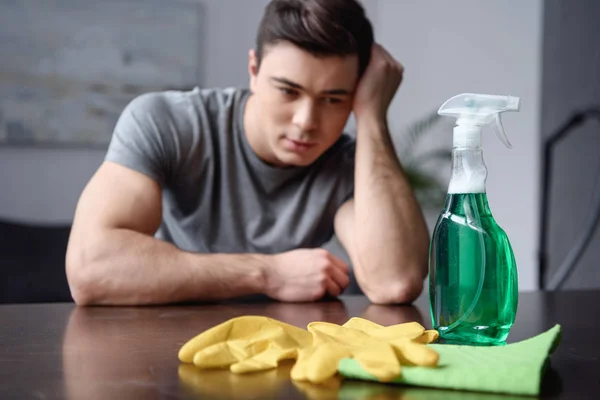 Handsome Man Sitting Table Looking Cleaning Stuff Living Room — Free Stock Photo