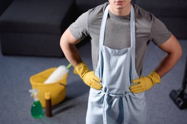cropped image of man standing in apron in living room