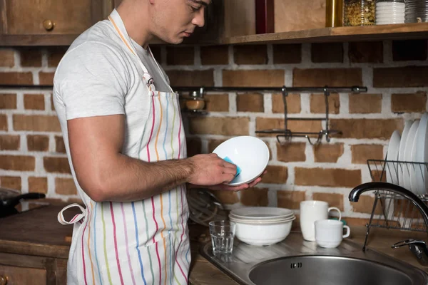 キッチンでお皿を洗う人の側面図 — ストック写真