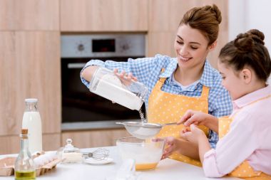 Anne ve kızı ile birlikte pasta için hamur hazırlama elek