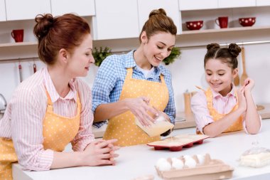 hamur kek mutfak at için formları birlikte pişirme içine dökülen kadınların üç kuşak