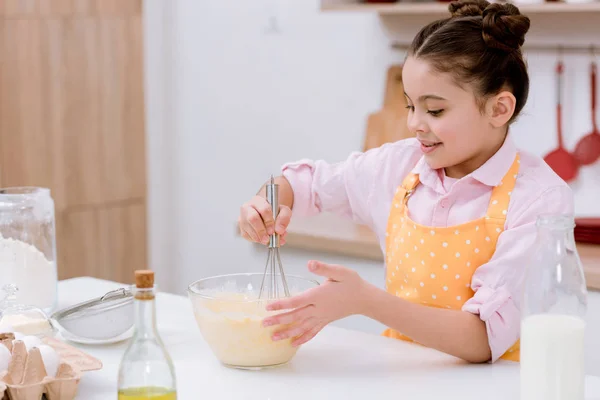 adorable little child mixing dough for pastry