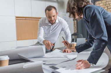 architects working with building plans together at modern office